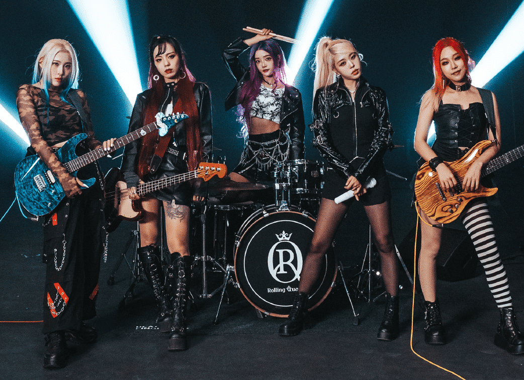 Rolling Quartz standing with their instruments in front of a dark background