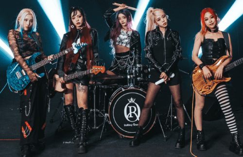 Rolling Quartz standing with their instruments in front of a dark background
